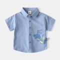 Dettaglio della camicia azzurra per bambino con stampa di dinosauro e tessuto di puro cotone - Blu / 90cm