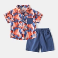 Flat lay of boys' summer set with multi-color abstract print shirt and navy blue shorts - Orange Blue Set / 90cm