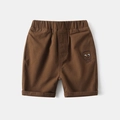 Detail of brown cotton kids shorts featuring elastic waist and smile face embroidery - Coffee / 100cm