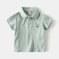 Detail eines minzgrünen Jungen-Poloshirts aus Baumwolle mit Dackel-Stickerei und Rippkragen - 90cm / Senfgrün