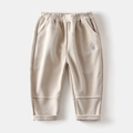 Detail of light beige corduroy pants featuring elastic waist and robot embroidery - Khaki / 90cm