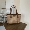 Dettaglio di una borsa tote in pelle marrone con pannello marmorizzato e etichetta - Marrone
