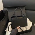 Minimalist black matte leather handbag with knotted handle and adjustable strap - Black
