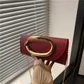 Elegant red leather clutch bag with large gold oval buckle and fine chain strap - Red