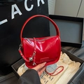 Rote Lack-Handtasche mit goldener Kette und Fashion-Emblem in modernem Lifestyle-Ambiente - Rot