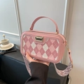Borsa a tracolla rosa con motivo a rombi e ampia tracolla geometrica in un ambiente caffè - Rosa