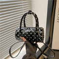 Zylindrische Handtasche mit Punkten aus schwarzem Lackleder mit Griffen und Schultergurt - Schwarz