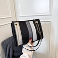 Elegante borsa tote in tela a righe bianche e grigie con catena dorata e manici neri - Nero