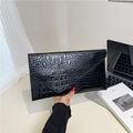 Black crocodile embossed envelope clutch bag shown in a professional office setting - Black