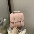 Pink mini backpack with crocodile pattern and golden buckles held on display stand - Pink
