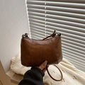 Brown retro PU leather shoulder bag with zipper on a white sweater background - Brown