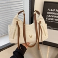 Chic beige textured leather tote bag with brown handles and gold deer emblem - White
