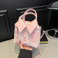 Bolso tipo cubo rosa con diseño de camisa, cuello y botones, sostenido a la mano - Rosa