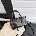 Glänzende schwarze Beuteltasche mit Knotengriffen und gelbem Mode-Schriftzug - Schwarz