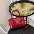 Retro dunkelrote Eimertasche aus glänzendem Leder mit Knoten und Metallelementen - Rot
