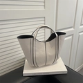 Minimalist beige bucket handbag with black decorative stitching and leather texture - White