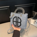 Schicke graue Filztasche mit schwarzem B-Logo und eleganten goldenen Metallbeschlägen - Blau