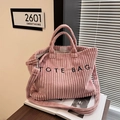 Sac cabas en velours côtelé rose avec lettrage TOTE BAG et bandoulière dans une pièce - Rose