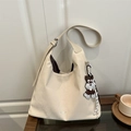 Minimalistische beige Hobo-Tasche mit breitem Schultergurt und Hunde-Anhänger - Mit Anhänger / Weiß