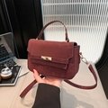 Elegant burgundy crossbody bag with gold twist-lock and matte finish in office setting - Red