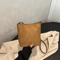 Brown frosted leather bucket bag with minimalist design and slim shoulder strap - Tan
