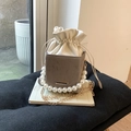 Détail du sac seau gris texturé avec poignée en perles et fine bandoulière dorée - Kaki