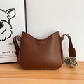 Vintage brown half-moon crossbody bag with a patterned wide jacquard strap on wood surface - Brown