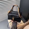 Schwarze Lederhandtasche mit goldenem Ovalverschluss und orange gemustertem Seidenschal - Schwarz