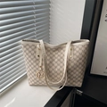 Schicke beige Monogramm-Tragetasche mit M-Muster und Goldanhänger in natürlichem Licht - Weiß