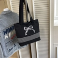 Detail of black canvas tote bag featuring white bow embroidery and large capacity design - Black