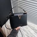 Bolso saco minimalista de cuero negro mate con logotipo en V de metal y correa fina - Negro