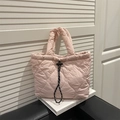 Pink heart quilted tote bag with black drawstring closure on leather chair - Pink