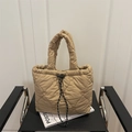 Khaki quilted tote bag with heart embroidery and drawstring detail on black chair - Khaki