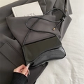 Black patent leather shoulder bag with irregular flap and knotted strap detail - Black