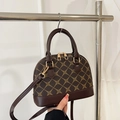 Vintage schelpvormige handtas met donkerbruin monogrampatroon en gouden hardware - Bruin