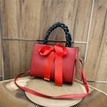 Borsa in pelle rossa con grande fiocco e manico intrecciato nero e tracolla regolabile - Rosso