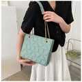 Detail of light green tote bag featuring 3D geometric pyramid texture and gold chain strap - Green