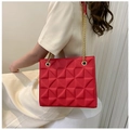 Détail d'un sac cabas rouge avec texture géométrique 3D et chaîne dorée - Rouge