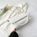Borsa a tracolla bianca con goffratura floreale e catena spessa su un blazer - Bianco