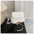 Detail of white saddle bag showing crocodile pattern texture and silver metal hardware - White