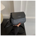 Detail of black saddle bag showing smooth and crocodile pattern leather texture with text - Black