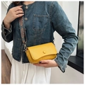 Yellow pebble grain crossbody bag with a Bohemian style colorful woven strap - Orange