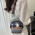 Ethnic woven bucket bag with colorful tassels and geometric patterned wide strap - Green