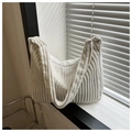 Detalle de la textura del bolso hobo de pana blanco crema en el alféizar de una ventana - Blanco
