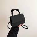 Moderne schwarze quadratische Handtasche mit Webstruktur, Knotengriff und goldenen Beschlägen - Schwarz