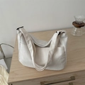 Minimalistische beige Cord-Tragetasche mit breitem Gurt und Außentasche auf Holztisch - Weiß