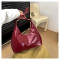 Detailopname van glanzende bordeauxrode hobo-tas met gelakte afwerking en metalen ringen - Rood