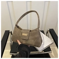 Detail of tan suede shoulder bag featuring a half-moon shape and golden metal buckle - Brown