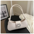 Macro detail of creamy leather underarm bag featuring a sparkling rhinestone square buckle - White
