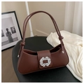 Close-up of brown baguette bag with shimmering rhinestone buckle and knotted handle details - Brown
